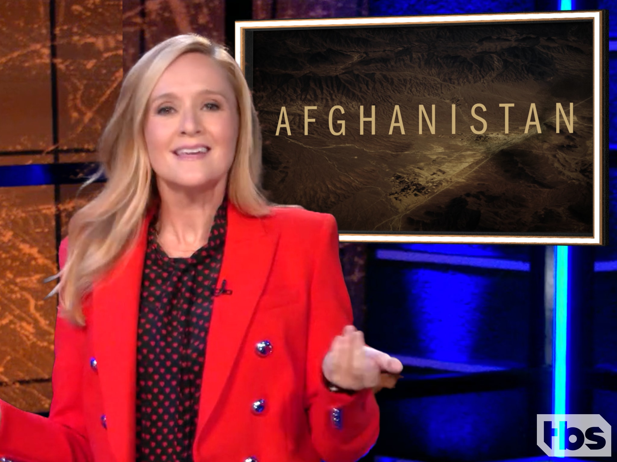 Full Frontal Samantha Bee in a red blazer with writing to her right that says Afghanistan